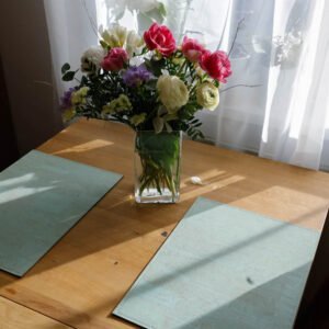 Sage green table mats bring a pop of color to the dining area, handmade products from a local manufactory